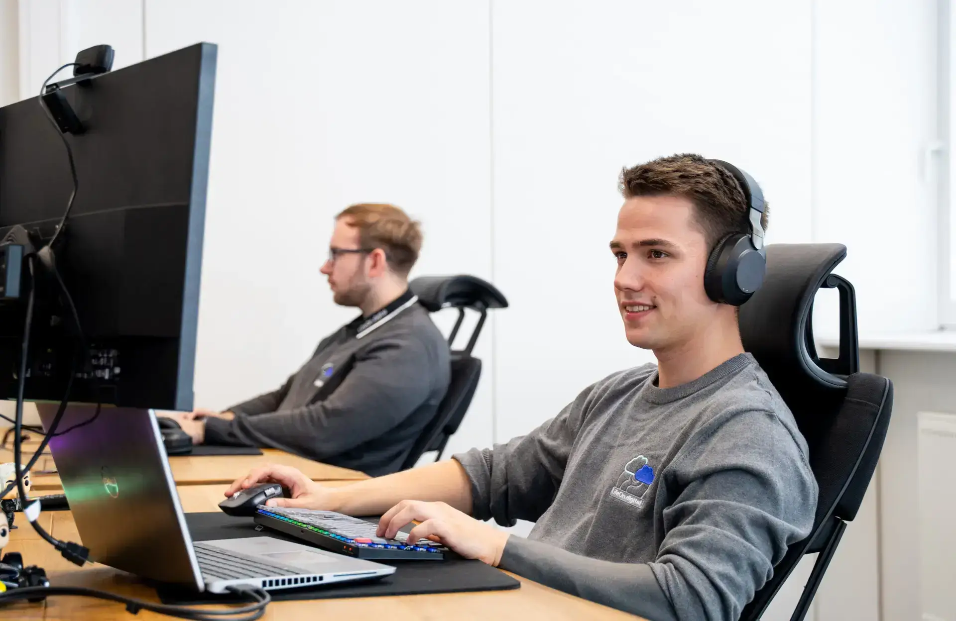 Zwei LifeOn.digital Mitarbeiter sitzen an einem Arbeitsplatz und arbeiten an der Digitalisierung von Geschäftsprozessen.
