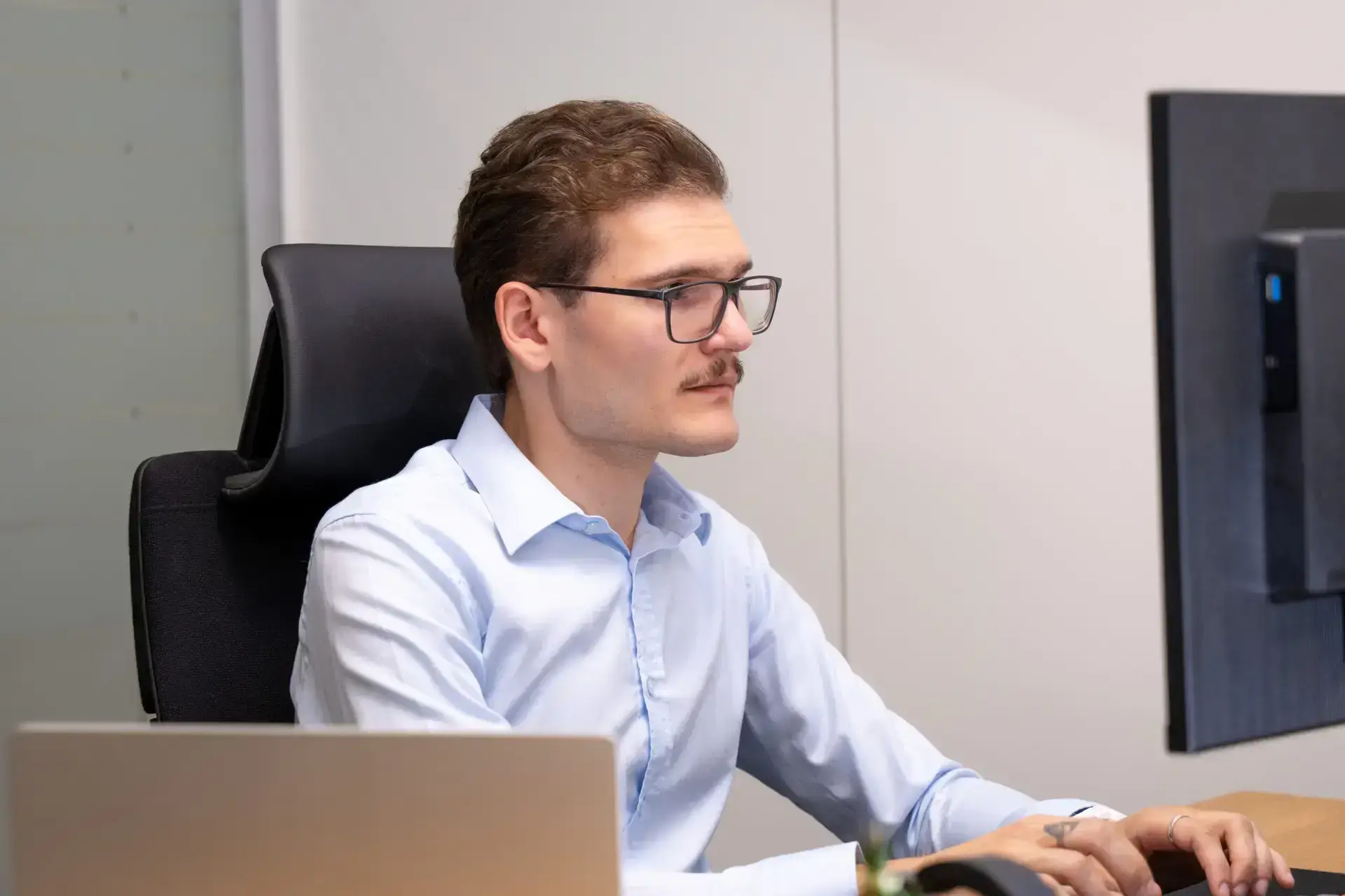 Ein LifeOn.digital Mitarbeiter sitzt an einem Arbeitstisch und erstellt ein Power BI Dashboard.