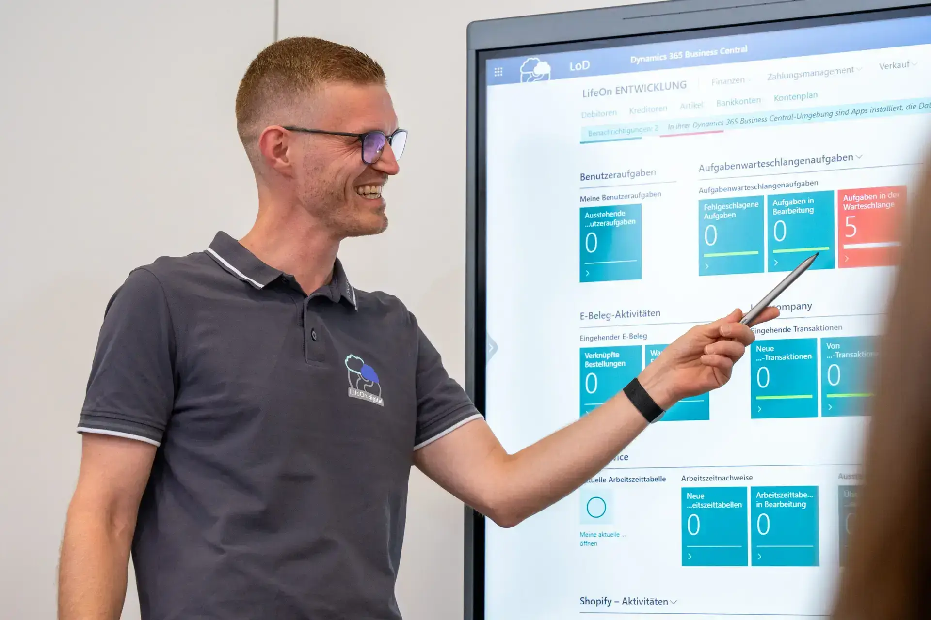 Ein LifeOn.digital Mitarbeiter hält einen Smartboard-Stift und führt durch ein Business Central Dashboard, eine ERP-Beratung.